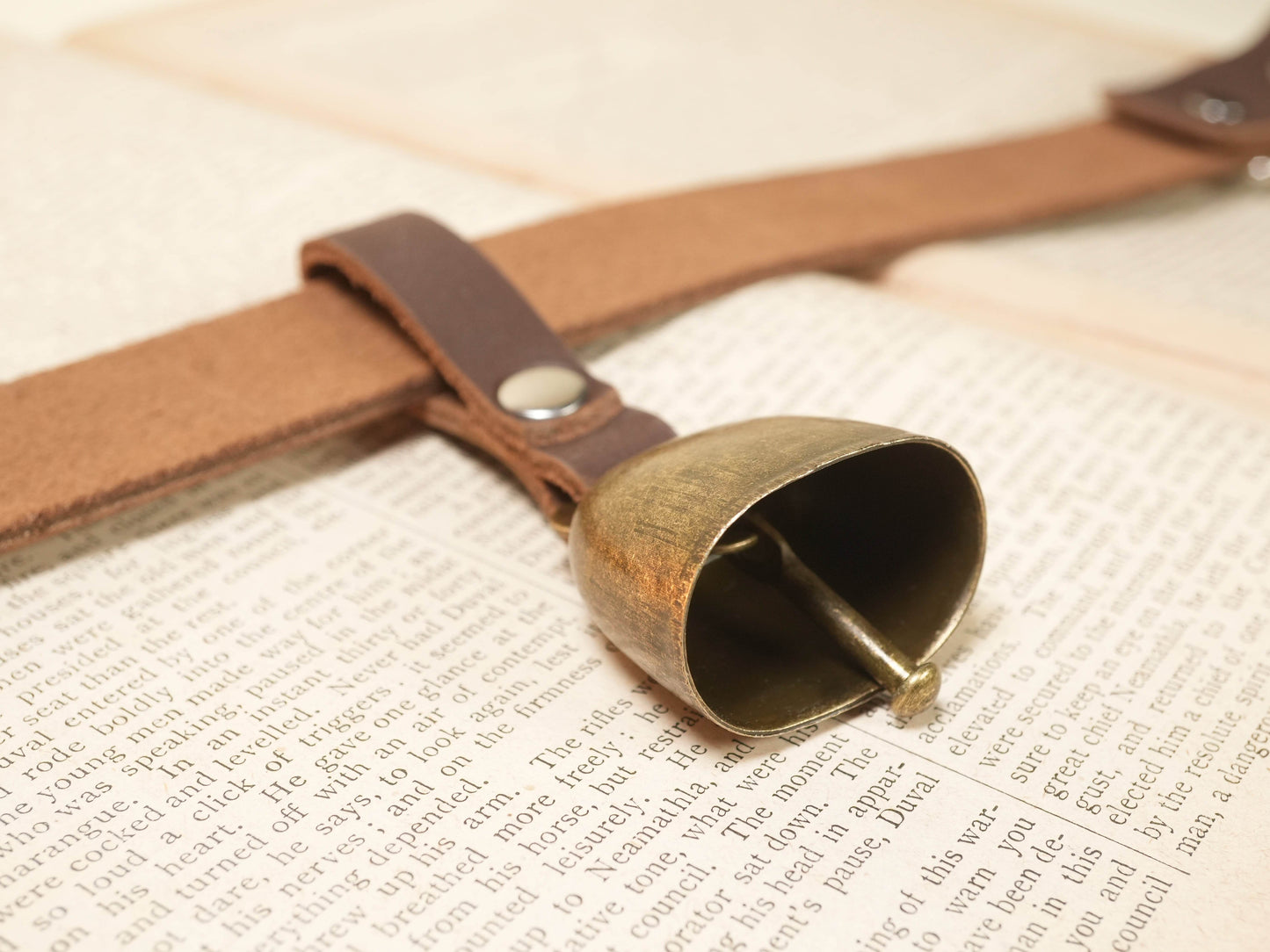 Hucow Collar by Bound by Dave featuring a leather strap with an attached rustic metal cowbell