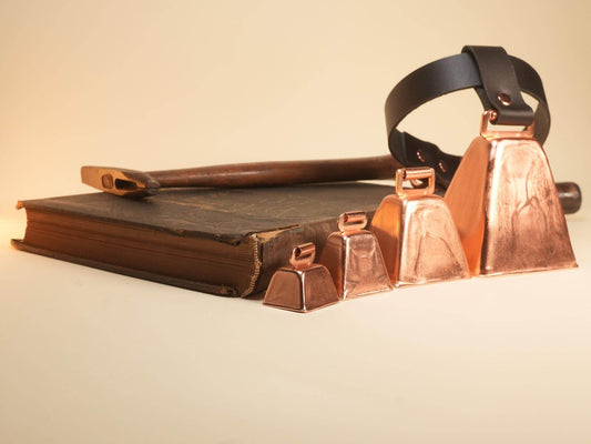 Bound by Dave copper Hucow Collar with adjustable black leather strap displayed with vintage book and wooden rod