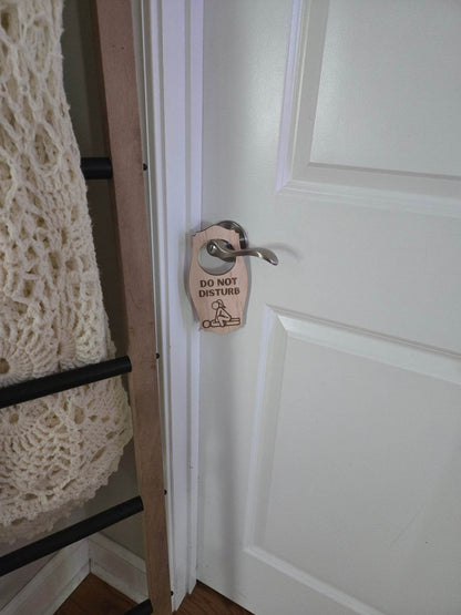 Adult do not disturb sign hanging on silver door handle of a white door in a cozy room