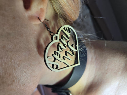 Bound by Dave wooden heart-shaped bdsm earrings with engraved text worn on ear