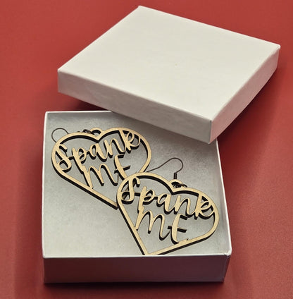 Bound by Dave wooden bdsm earrings in heart shape with Spank Me text inside displayed in white box