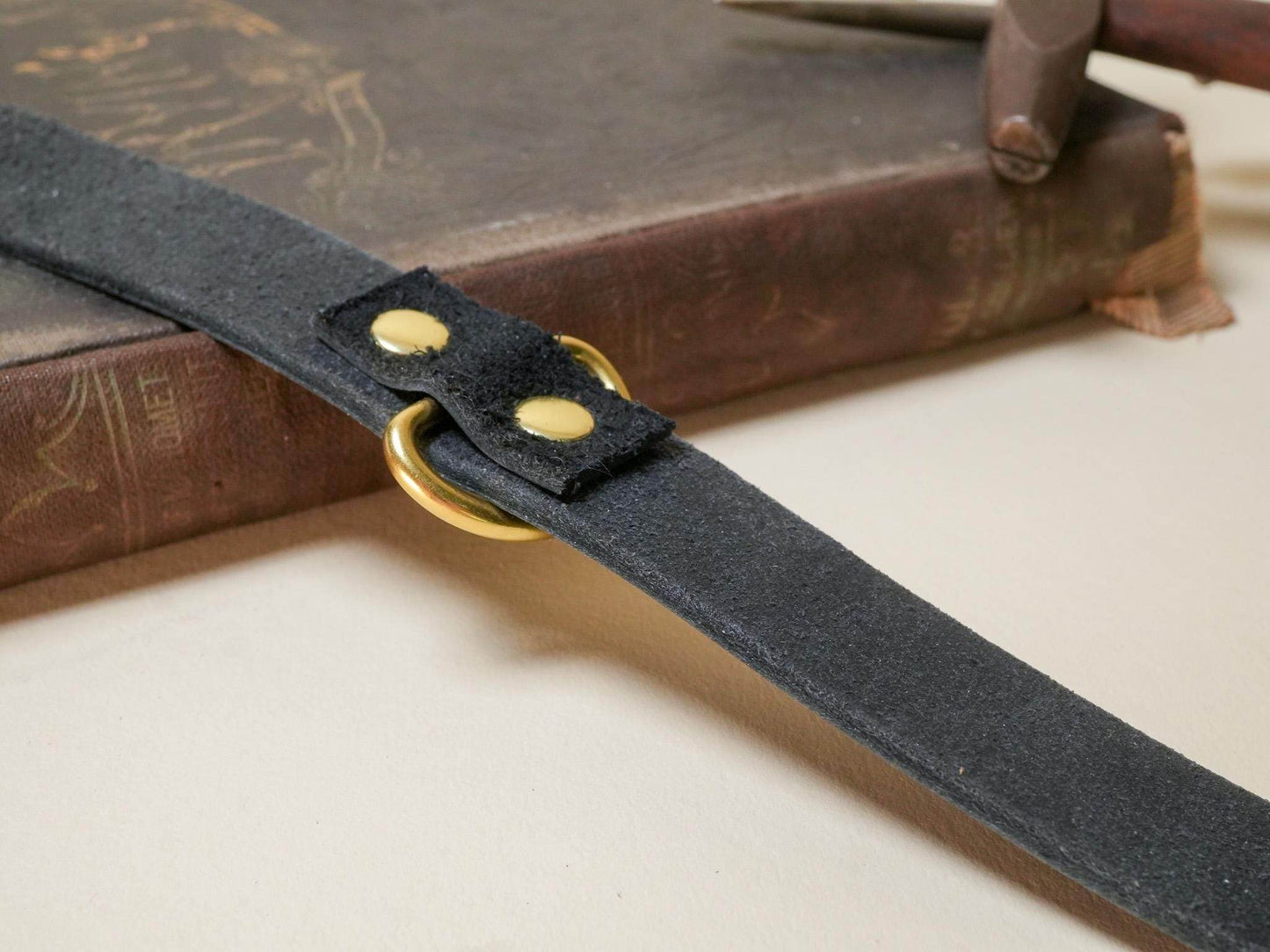 Bound by Dave black suede day collar with brass hardware on a vintage book background