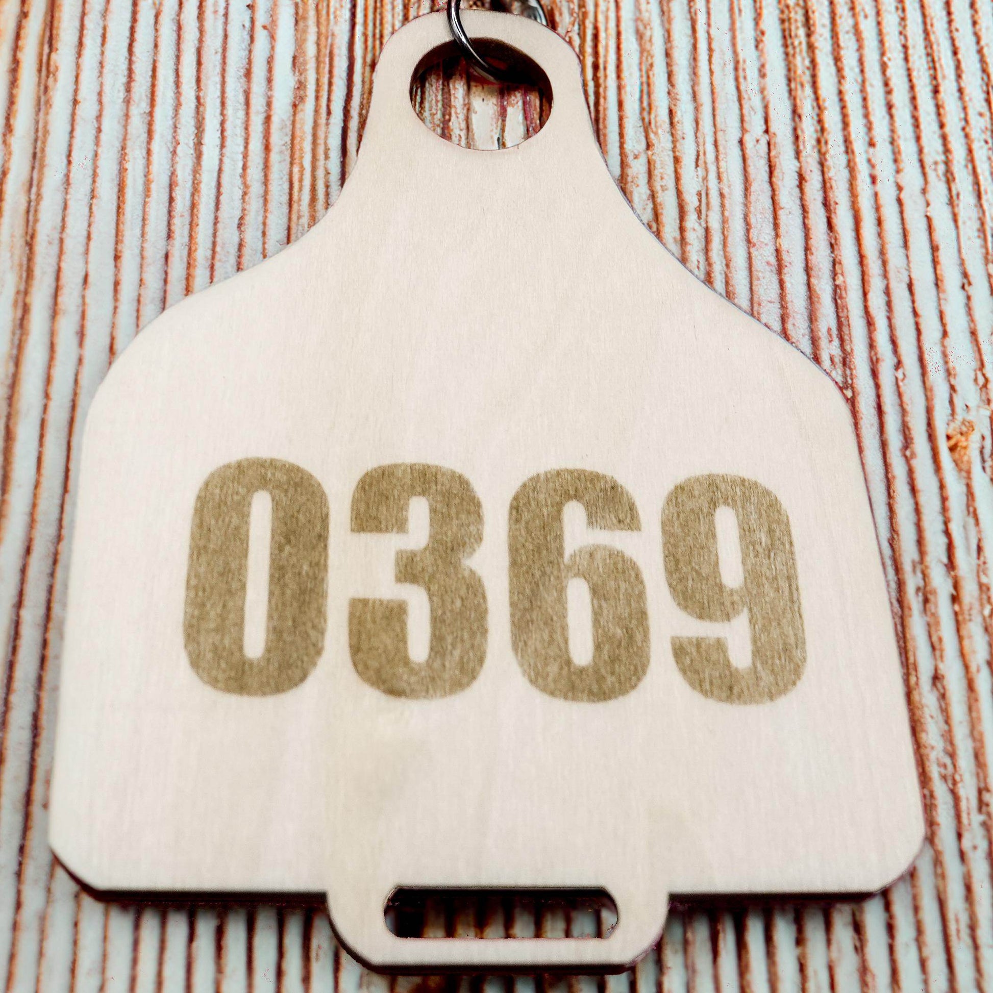 Wooden Cow Tag with number 0369 by Bound by Dave on a rustic wooden background