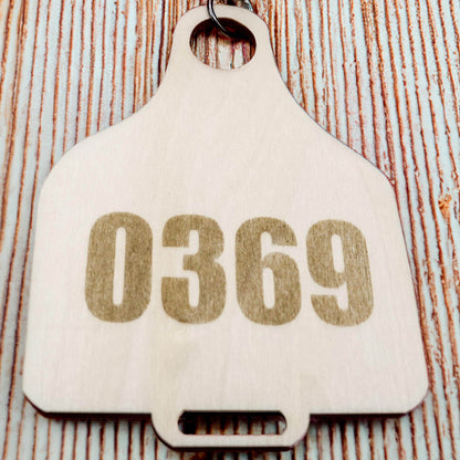 Wooden Cow Tag with number 0369 by Bound by Dave on a rustic wooden background