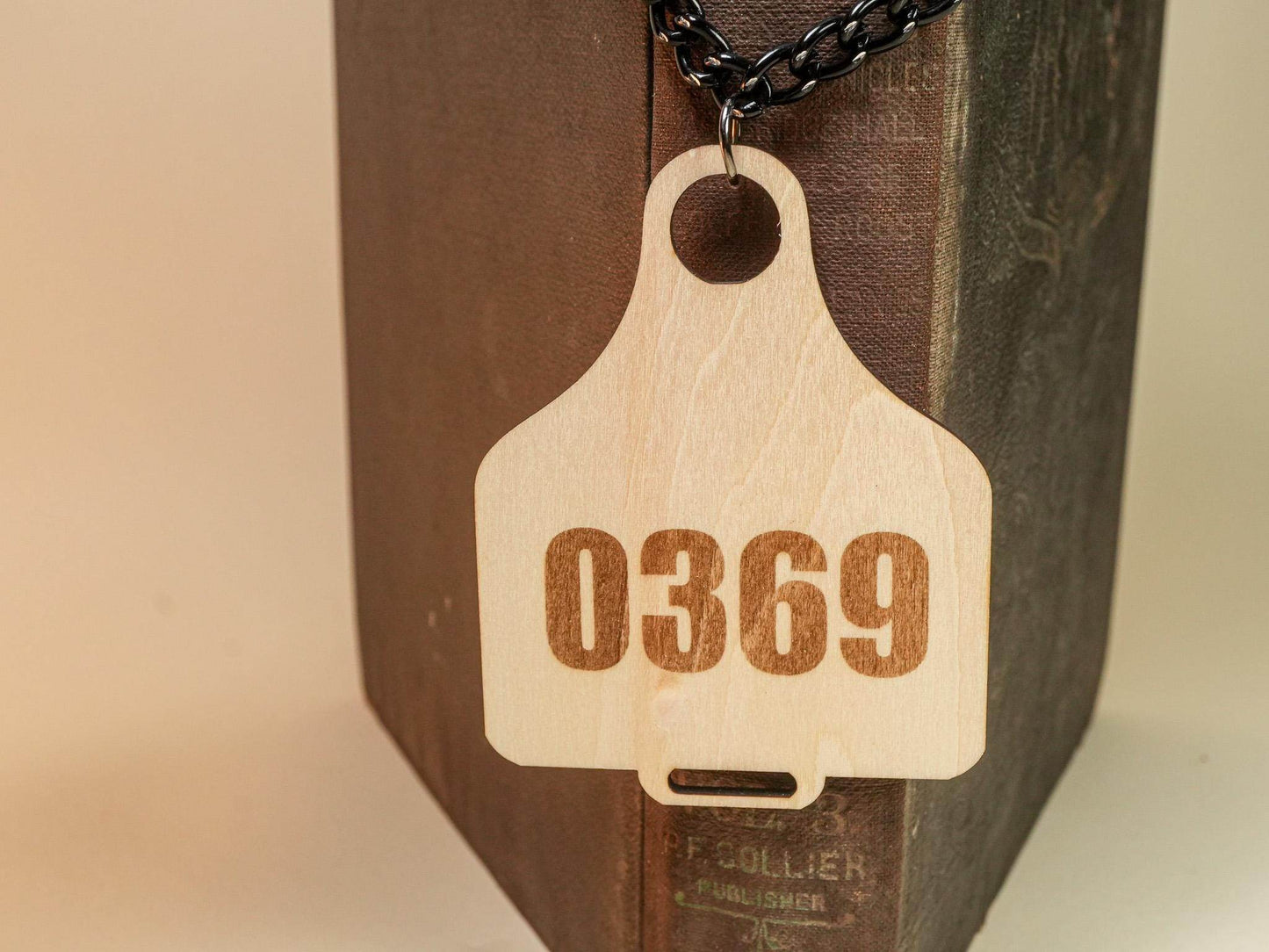 Bound by Dave wooden Cow Tag with number 0369 on a black chain necklace
