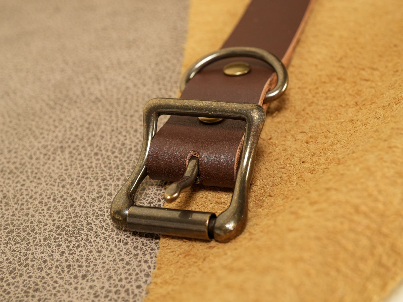Close-up of brown leather cowbell strap with brass buckle and metal ring from Bound by Dave