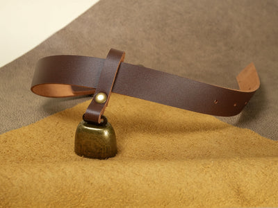 Boundary by Dave leather strap cowbell with brass bell on suede surface