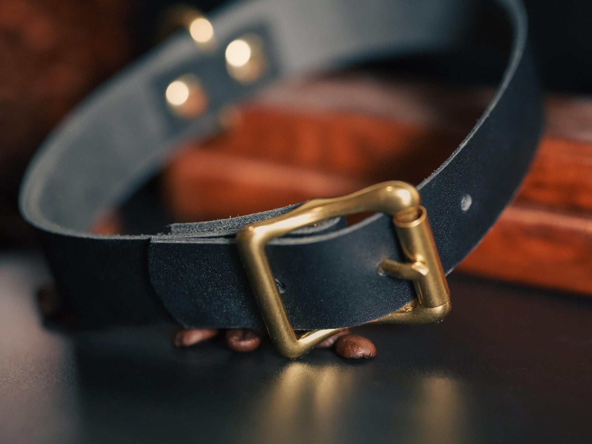 Bound by Dave black leather day collar with brass buckle on dark surface