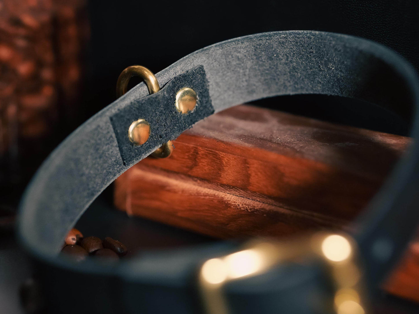 Bound by Dave black leather day collar with brass hardware resting on wooden surface