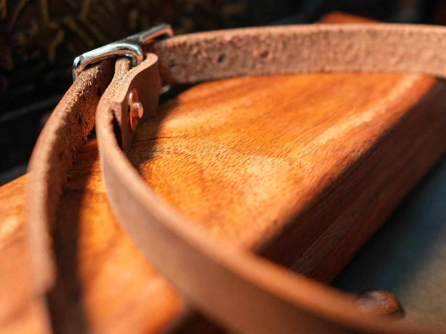Brown leather hucow choker collar with silver buckle on wooden surface by Bound by Dave