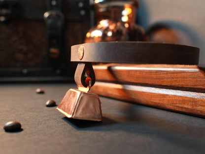 Bound by Dave hucow choker with leather strap and metal bell on wooden surface