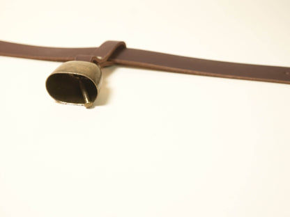 Brown leather Hucow Collar with attached metal bell by Bound by Dave on white background