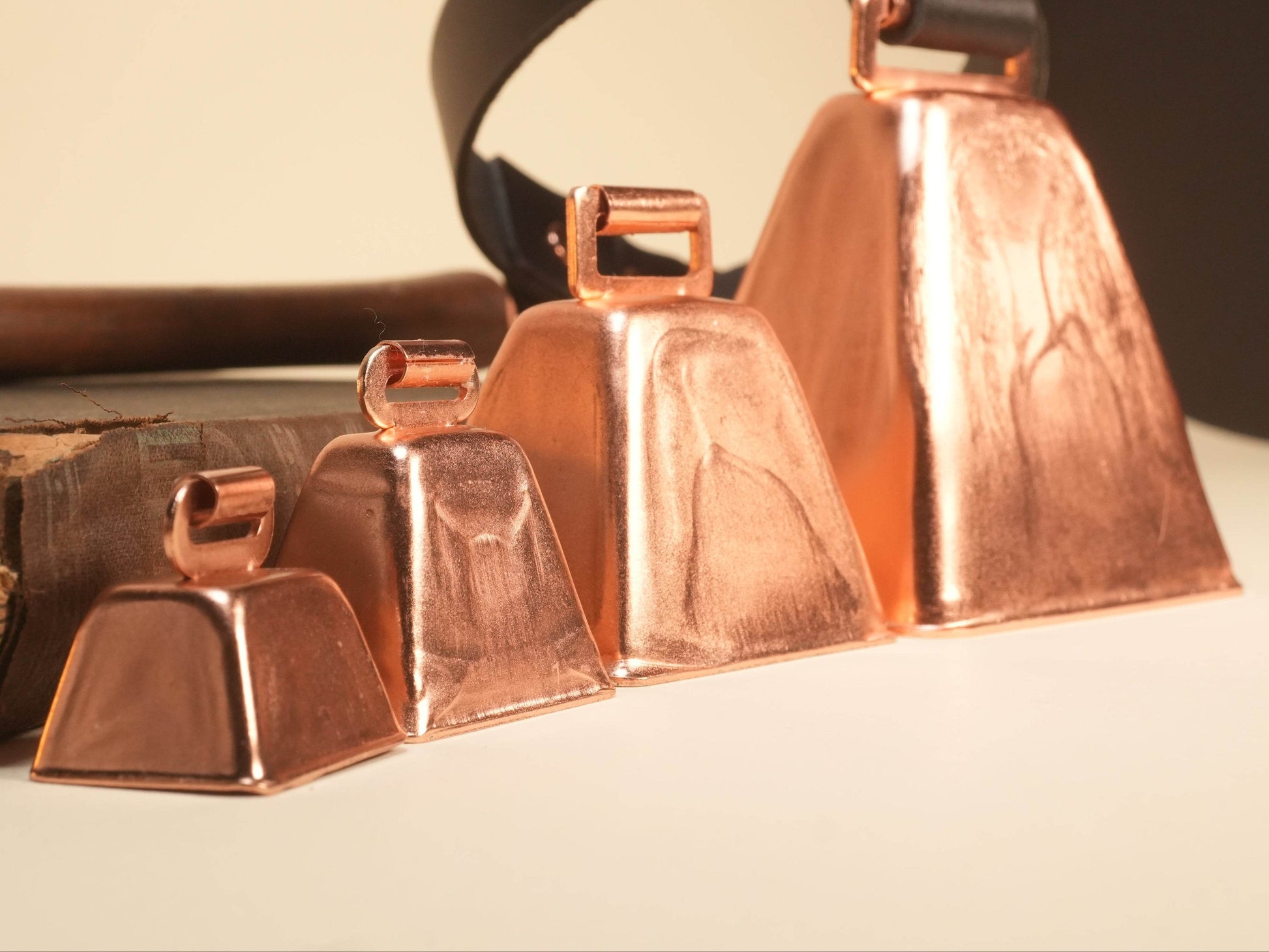 Set of four copper Hucow Collars in varying sizes by Bound by Dave with black strap background
