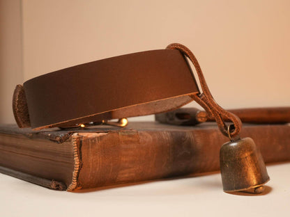 Bound by Dave brown leather Hucow Collar with rustic metal bell on vintage book