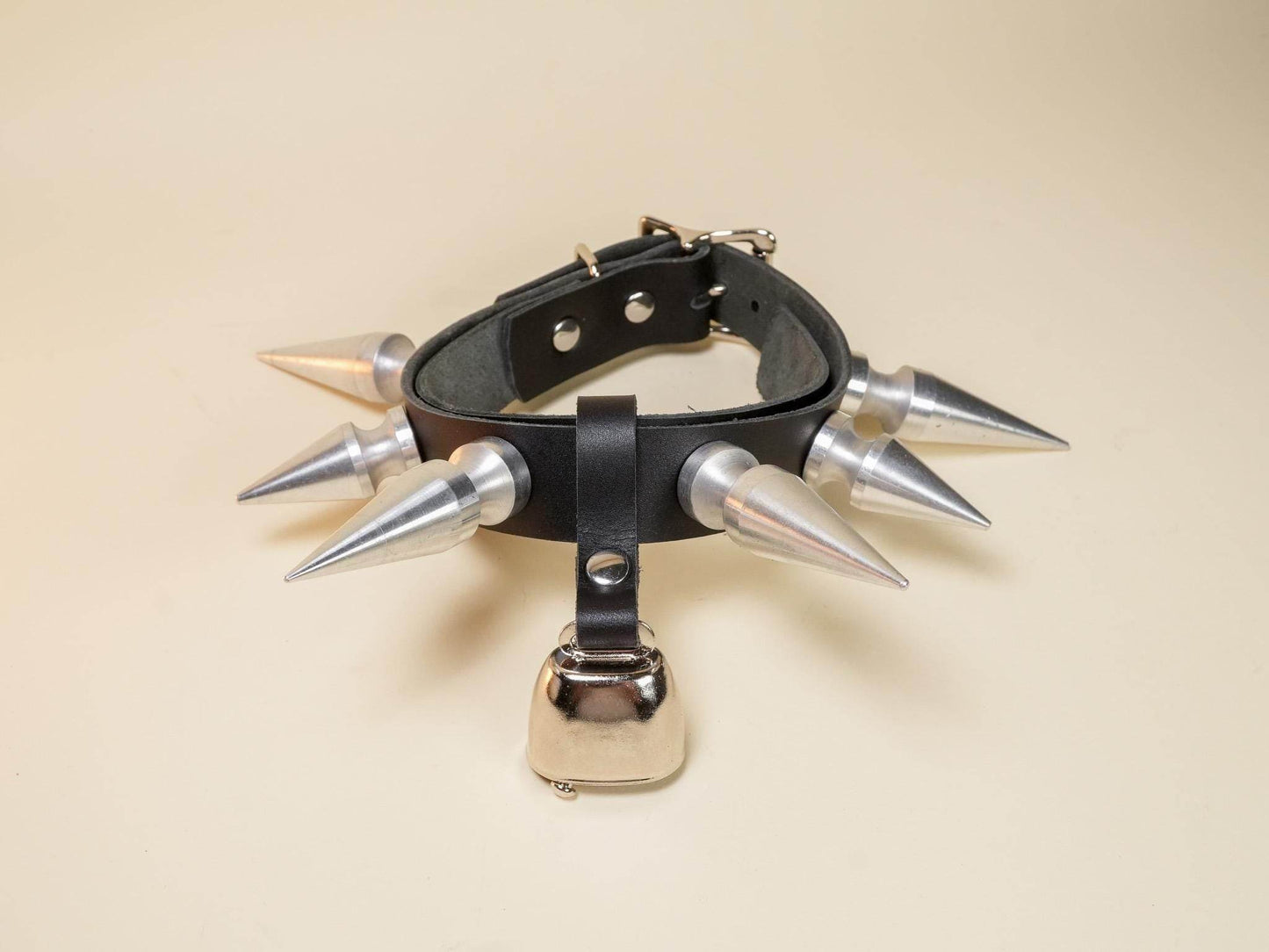 Black leather hucow collar with large silver spikes and a metal bell by Bound by Dave