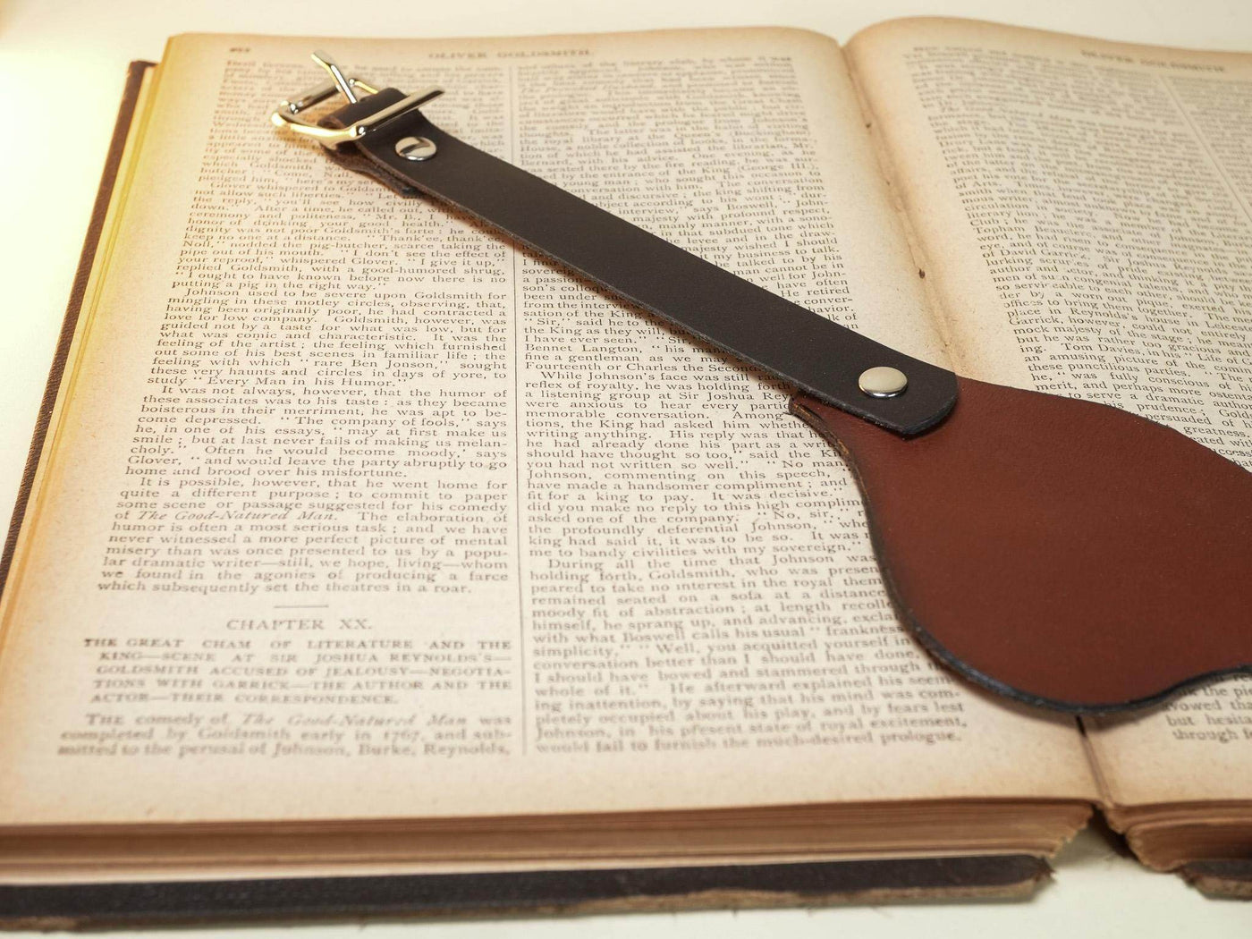 Leather Blindfold by Bound by Dave in brown leather with buckle strap on open book background