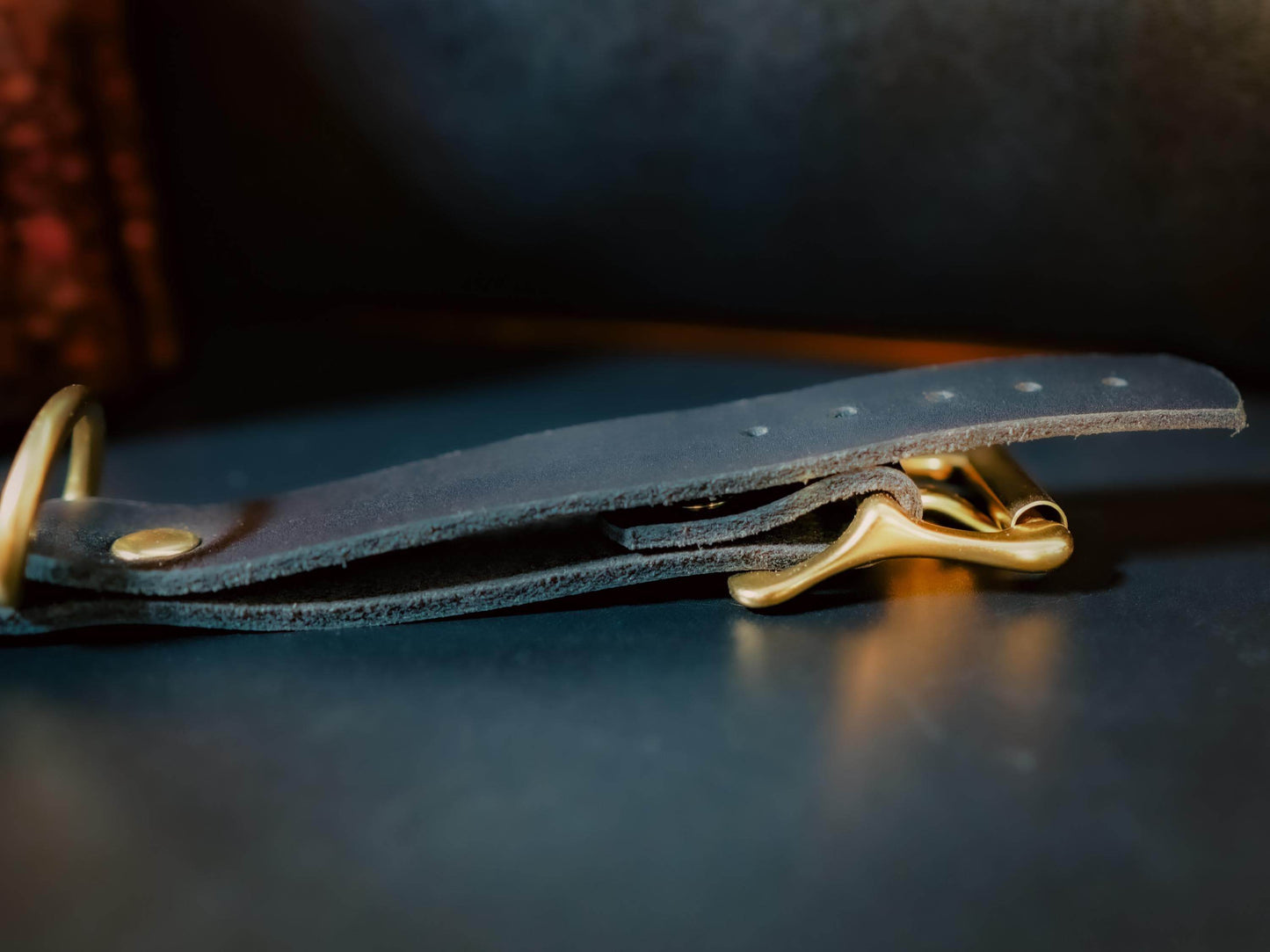 Bound by Dave black leather hand cuffs with gold metal buckle and rivet detail close-up