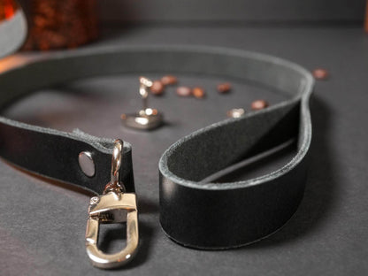 Black leather Locking Collar with metal clasp from Bound by Dave on dark surface