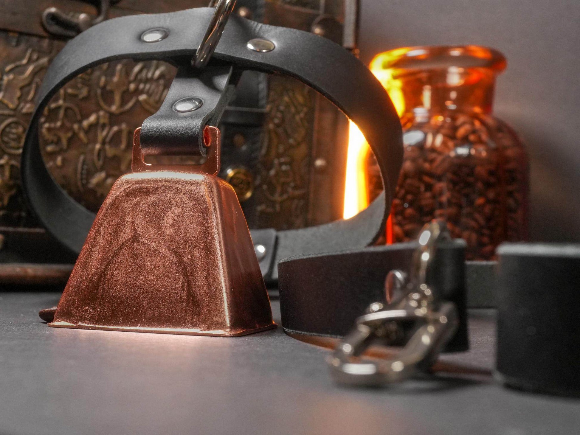 Bound by Dave locking collar with brown leather bell and black adjustable strap on dark surface