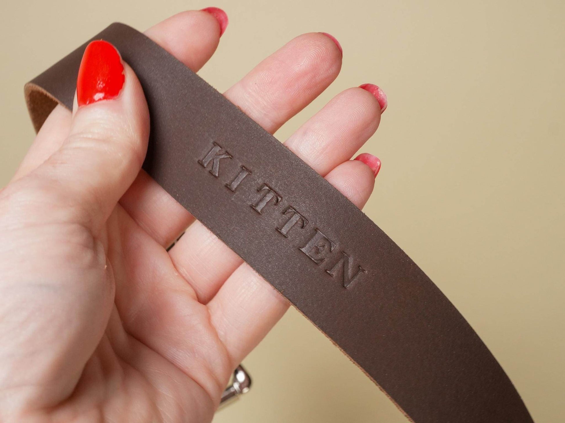 Bound by Dave brown leather Locking Sub Collar with embossed KITTEN text held in hand