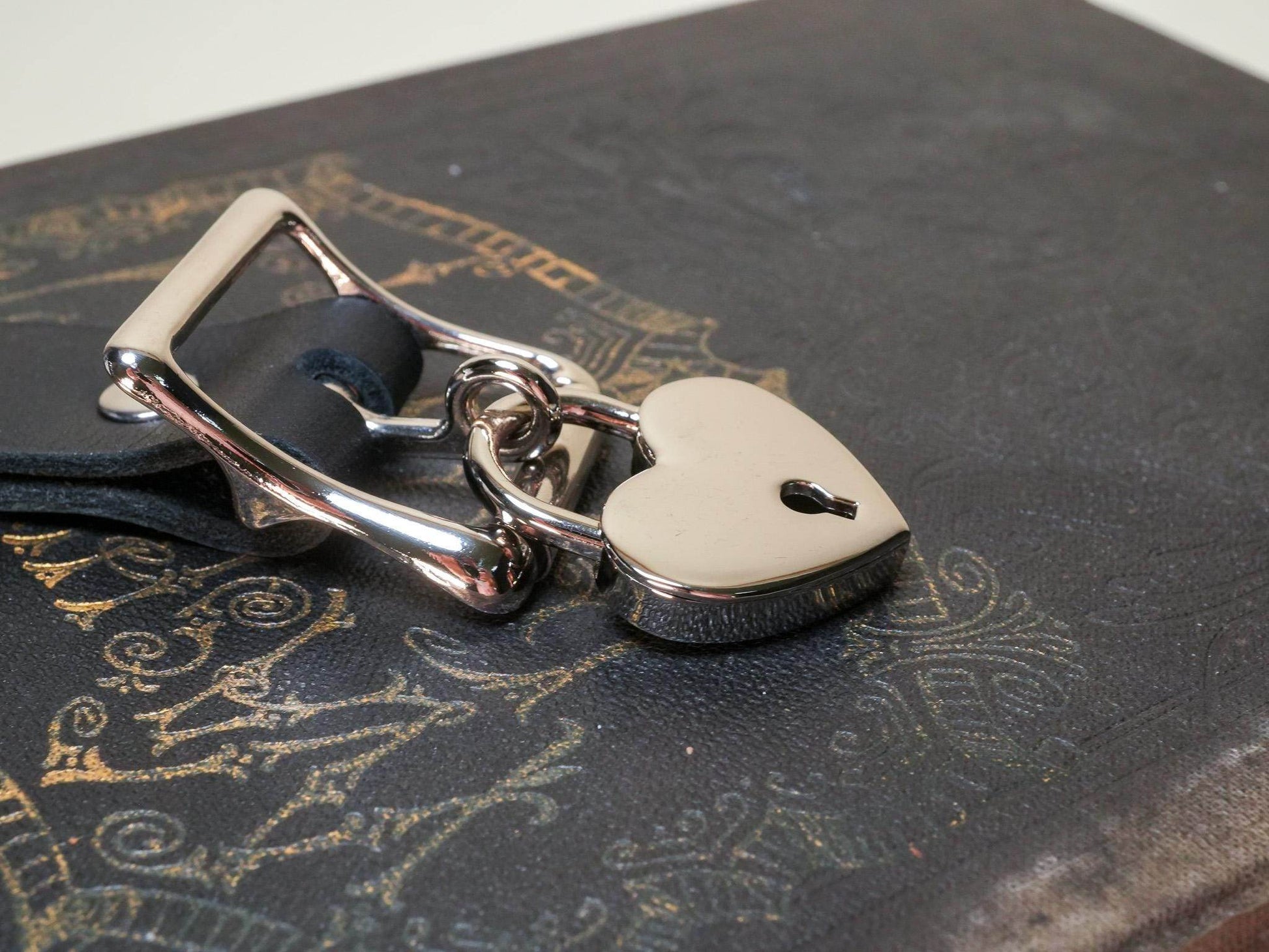 Bound by Dave Locking Sub Collar with heart-shaped lock on black textured surface