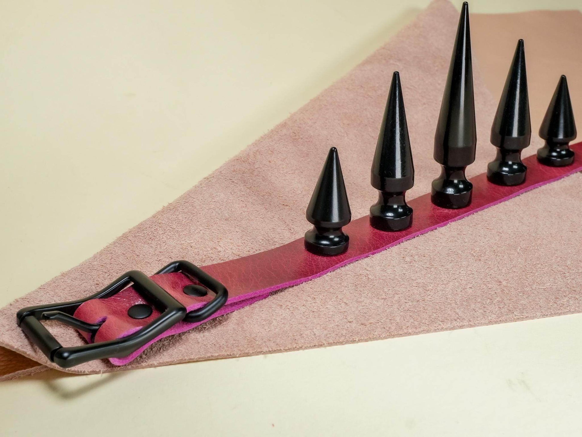 Bound by Dave black spike leather Rave Choker with adjustable buckle on pink fabric background