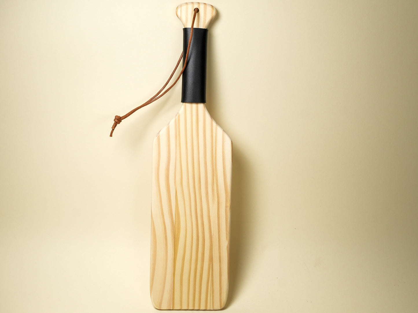 Bound by Dave wooden spanking paddle with black handle grip and leather wrist strap