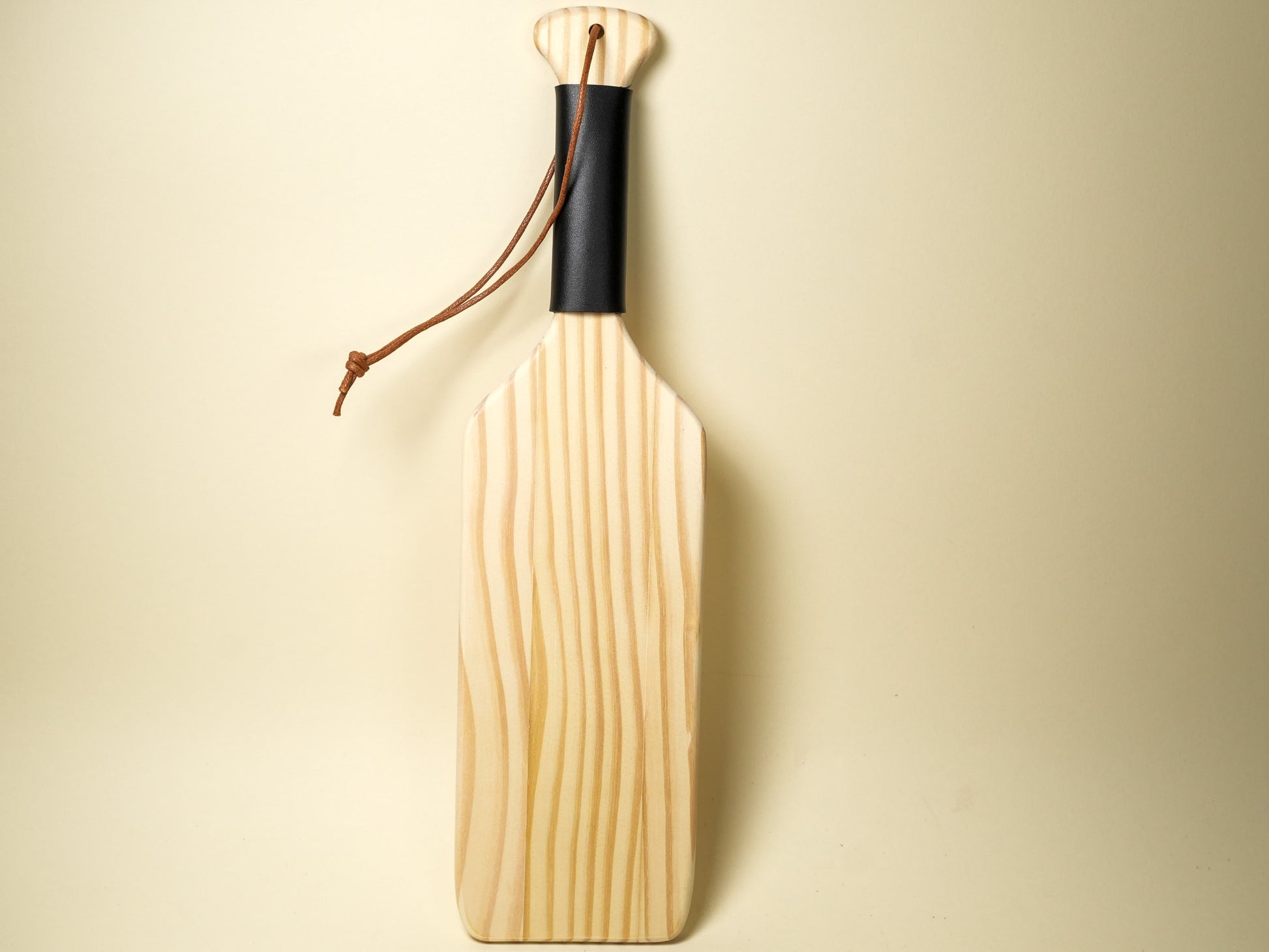 Bound by Dave wooden spanking paddle with black handle grip and leather wrist strap