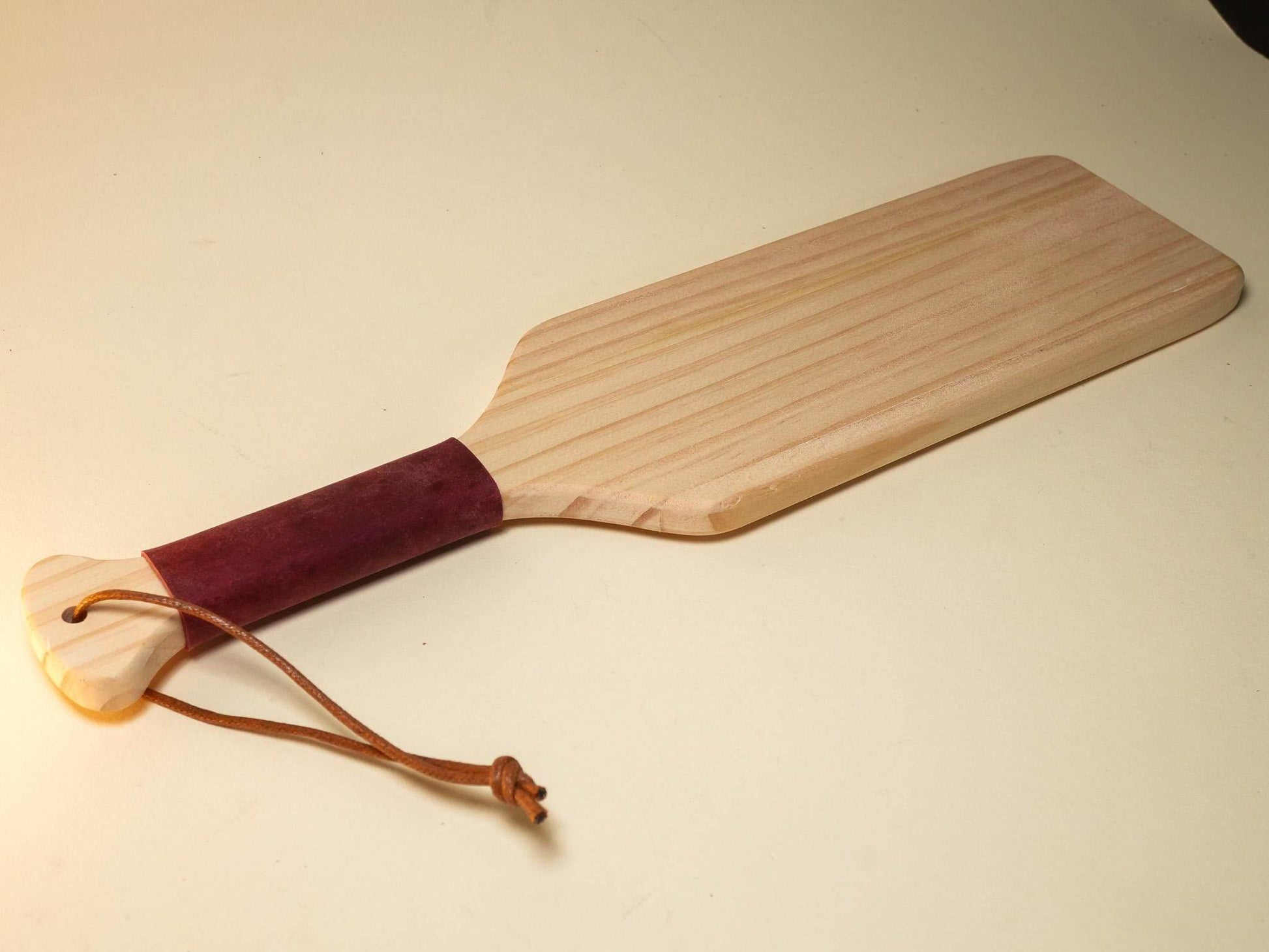 Bound by Dave wooden Spanking Paddle with leather-wrapped handle and wrist strap