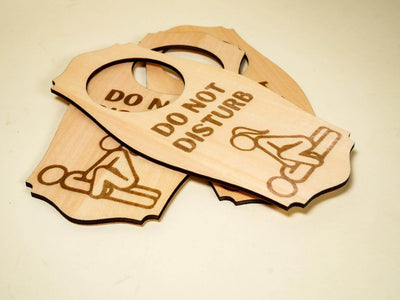 Wooden adult do not disturb sign with engraved text and adult-themed illustration