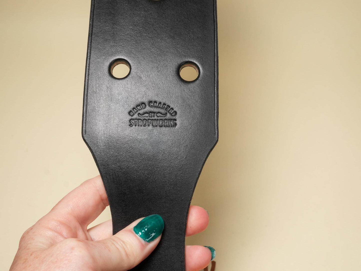 Bound by Dave black leather paddle with two round holes branded with embossed logo leather paddle holes