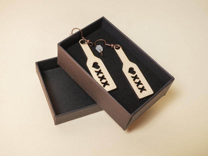 Wood spanking paddle earrings with heart and XXX cutout design in a black gift box by Bound by Dave